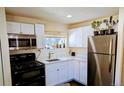 Well-equipped kitchen with white cabinets, stainless steel appliances, and a garden window at 6710 Clermont St, Commerce City, CO 80022