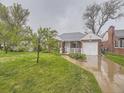 Quaint red brick house with a well-maintained lawn and inviting curb appeal at 5703 Ammons St, Arvada, CO 80002
