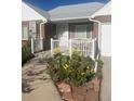 Inviting front porch adorned with colorful flowers and a charming white railing at 5703 Ammons St, Arvada, CO 80002