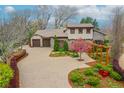 Beautiful home featuring an attached garage, a blooming tree and an inviting walkway with an overhead trellis at 1423 E Fair Pl, Centennial, CO 80121