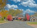 An inviting residence surrounded by colorful autumn trees and greenery under a bright blue sky with puffy white clouds at 1423 E Fair Pl, Centennial, CO 80121