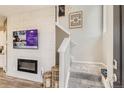 Living room featuring a fireplace, staircase, and large TV at 6932 Huddersfield Ln, Castle Pines, CO 80108