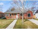 Charming red brick single-story home with sidewalk and bare trees in the yard at 1273 S Jackson St, Denver, CO 80210