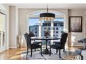 Bright dining area featuring a round table with black chairs and a modern chandelier against a backdrop of city views at 1827 N Grant St # 1000, Denver, CO 80203