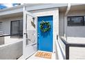 Charming entryway with a vibrant blue door adorned with a wreath and 'Hello' welcome mat at 1830 Newland Ct # 321, Lakewood, CO 80214