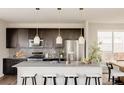 Modern kitchen features dark cabinets, stainless steel appliances, granite countertops, and pendant lighting at 11090 E 26Th Ave, Aurora, CO 80010