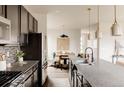 Open-concept kitchen featuring stainless steel appliances, an island with bar seating, and wood floors at 11090 E 26Th Ave, Aurora, CO 80010