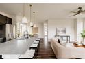 Open floor plan featuring a kitchen island with seating connecting to the living room with modern decor at 11090 E 26Th Ave, Aurora, CO 80010