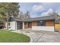 Well-maintained home featuring a modern garage door, nice lawn, and driveway in a suburban neighborhood at 920 S Hudson St, Denver, CO 80246