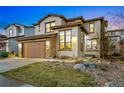 Charming two-story home featuring a two-car garage, stone accents, manicured landscaping, and exterior lighting at 15275 W La Salle Ave, Lakewood, CO 80228