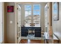 Home office with French doors, an accent wall, a large desk, and views of the front yard at 15275 W La Salle Ave, Lakewood, CO 80228