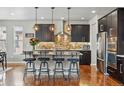 Modern kitchen featuring stainless steel appliances, dark cabinetry, granite countertops, and bar stool seating at 15275 W La Salle Ave, Lakewood, CO 80228