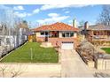 Well-maintained home with a red tile roof, attached garage, and lush front lawn at 5055 W 33Rd Ave, Denver, CO 80212