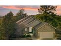 Lovely single-story home with a stone-accented attached garage and welcoming front porch, surrounded by lush trees at 7649 Pineridge Ter, Castle Pines, CO 80108