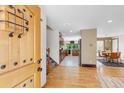 Welcoming foyer with hardwood floors, staircase, and views into the kitchen and dining area at 8272 Ammons Cir, Arvada, CO 80005