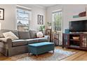 Comfortable living room with a gray sofa, wood floors, and large windows providing natural light at 6330 E 13Th Ave, Denver, CO 80220