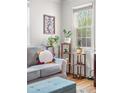 Cozy living room showing plants and shelves by a sunlit window and comfortable seating at 6330 E 13Th Ave, Denver, CO 80220