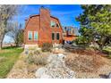Rear exterior showcasing a log home with a patio area and scenic landscaping at 48155 E 56Th Ave, Bennett, CO 80102