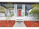 Inviting front porch with white columns, a red door with wreath, and a 'welcome' sign at 3186 Springmeadow Cir, Castle Rock, CO 80109