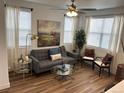 Bright living room with hardwood floors, modern furniture, and large windows for plenty of natural light at 9756 Ash Ln, Thornton, CO 80229