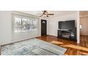 Bright living room with hardwood floors, a large window, ceiling fan, and a modern fireplace entertainment center at 1364 Lansing St, Aurora, CO 80010
