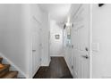 Well-lit hallway featuring hardwood floors, white doors, and neutral wall color at 2231 E 128Th Ave, Thornton, CO 80241