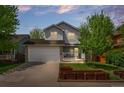 Charming two-story home with a well-manicured front yard, a porch, and an attached garage at 13245 Shoshone St, Denver, CO 80234