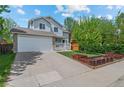 Inviting two-story home with a manicured lawn, a porch, and an attached two-car garage at 13245 Shoshone St, Denver, CO 80234
