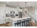 Bright kitchen with white cabinets, stainless steel appliances, large island and pendant lighting at 14096 Red Cosmos St, Parker, CO 80134