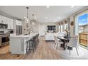 Open-concept living space featuring a modern kitchen, dining area, living room, and sliding door to the backyard at 14096 Red Cosmos St, Parker, CO 80134