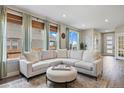 Comfortable living room featuring a sectional sofa, round ottoman, layered textures and window views at 14096 Red Cosmos St, Parker, CO 80134
