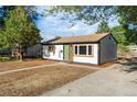 View of a single-story home with updated exterior featuring a green door and new windows at 3980 S Hazel Ct, Englewood, CO 80110