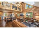 Spacious open-concept living room with log walls, hardwood floors, and large windows showcasing the natural surroundings at 5724 Highway 9, Breckenridge, CO 80424