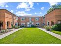 Full exterior view of a brick townhouse complex with a well-maintained central lawn area, showcasing its inviting community at 2858 Jasmine St, Denver, CO 80207