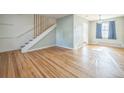 Bright living room featuring hardwood floors, light-colored walls, and a staircase leading to the upper level at 2858 Jasmine St, Denver, CO 80207