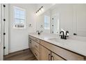 Bathroom showcasing a double sink vanity with modern black hardware and a large mirror at 8616 Pennycress Dr, Littleton, CO 80125