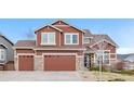 Inviting two-story house featuring a well-kept lawn, stone accents, and a convenient two-car garage at 3234 El Charro Pt, Castle Rock, CO 80108