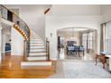 Elegant foyer with a curved staircase, wood floors, and an open view to the formal dining area at 3234 El Charro Pt, Castle Rock, CO 80108