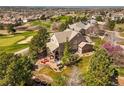 Gorgeous home overlooking the golf course with a brick patio, hot tub, and outdoor seating with mature landscaping at 6462 S Versailles Ct, Aurora, CO 80016