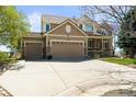 Charming two-story home with a three-car garage, covered porch, mature landscaping, and neutral exterior paint at 6462 S Versailles Ct, Aurora, CO 80016