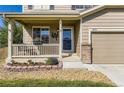 Close-up of the front porch with swing and well landscaped flower beds at 5090 Miriam Ln, Parker, CO 80134