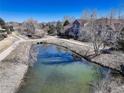 Scenic view of the community pond, reflecting the blue sky, nearby walking paths and well maintained landscaping at 6068 W Utah Ln, Lakewood, CO 80232