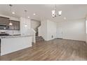Bright and airy living space featuring modern flooring, stairs to the second floor, and access to the kitchen at 21821 E 7Th Ave, Aurora, CO 80018