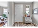 Neutral entryway with a white front door, wood flooring, mirror and cabinet at 3778 Happyheart Way, Castle Rock, CO 80109