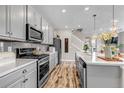 Stylish kitchen with gray cabinets, modern appliances, quartz countertops, and wood flooring at 3778 Happyheart Way, Castle Rock, CO 80109