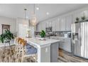 Bright kitchen with gray cabinets, stainless steel appliances, and island seating at 3778 Happyheart Way, Castle Rock, CO 80109