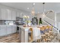 Modern kitchen with gray cabinets, quartz countertops, pendant lighting, and seating at the island at 3778 Happyheart Way, Castle Rock, CO 80109