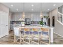 Open kitchen with pendant lights, large island, grey cabinets, and stainless steel appliances at 3778 Happyheart Way, Castle Rock, CO 80109
