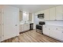 Modern kitchen featuring stainless steel appliances, white cabinets, and stylish backsplash at 6010 S Garland Way, Littleton, CO 80123