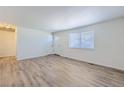 Spacious living room with new floor, fresh paint, and natural light from the large window at 6010 S Garland Way, Littleton, CO 80123